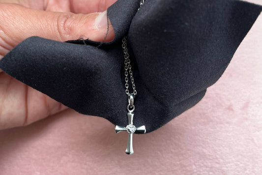 Silver necklace with cross pendant and cleaning cloth