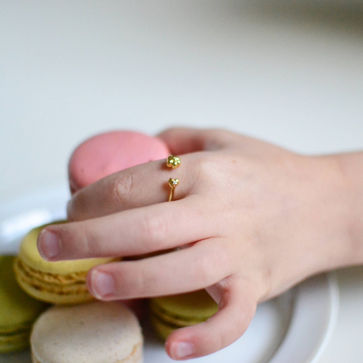 Little girl wearing Gold Sweet Flower and Heart with Diamond Open Ring reaching for macarons